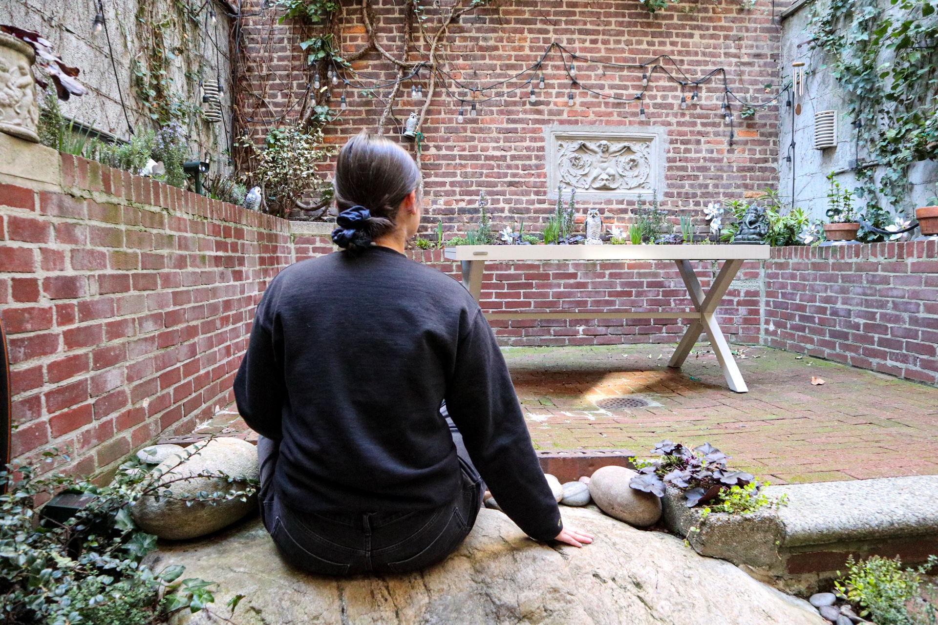 Someone sitting with Fred, the grounding rock in the Secret Garden — a place out of time