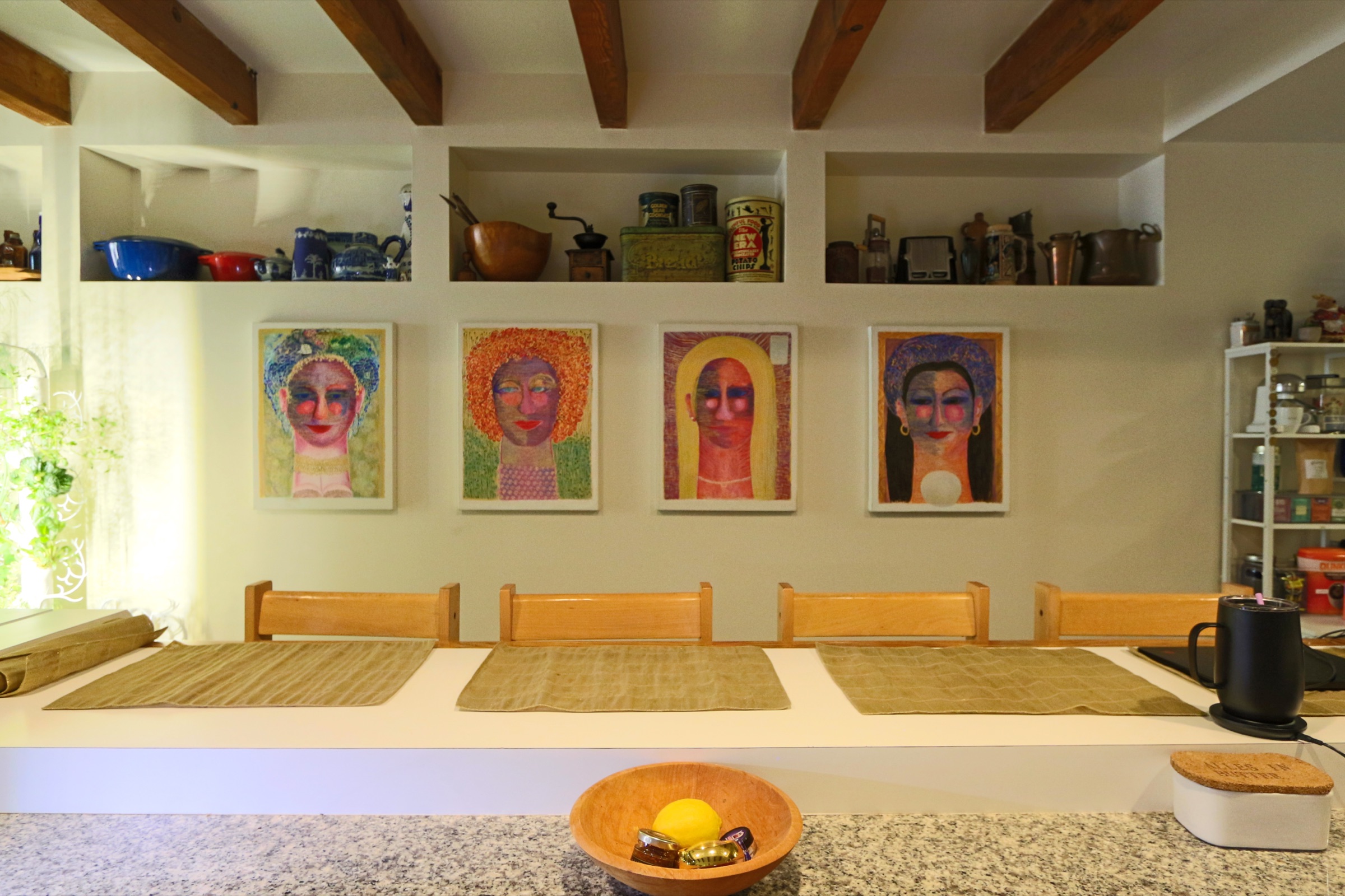 The long table at Sprout Kitchen with portrait paintings on the wall