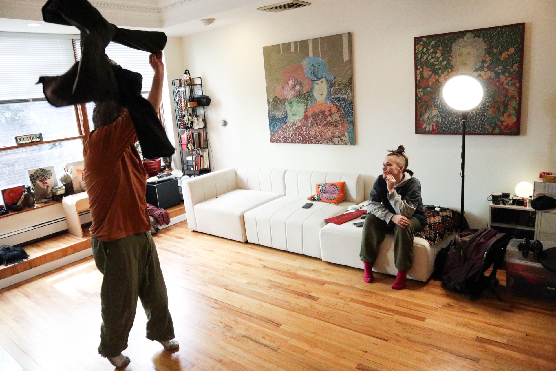 Maqks mid-rehearsal, fabric in motion, watched by a collaborator in the studio